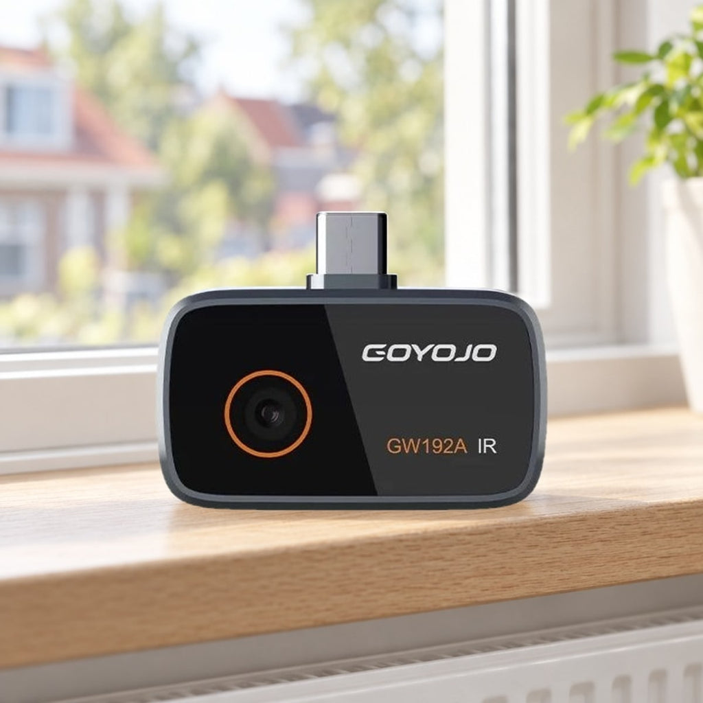 Warmtebeeldcamera met USB-C-stekker op een eikenhouten vensterbank voor een raam
