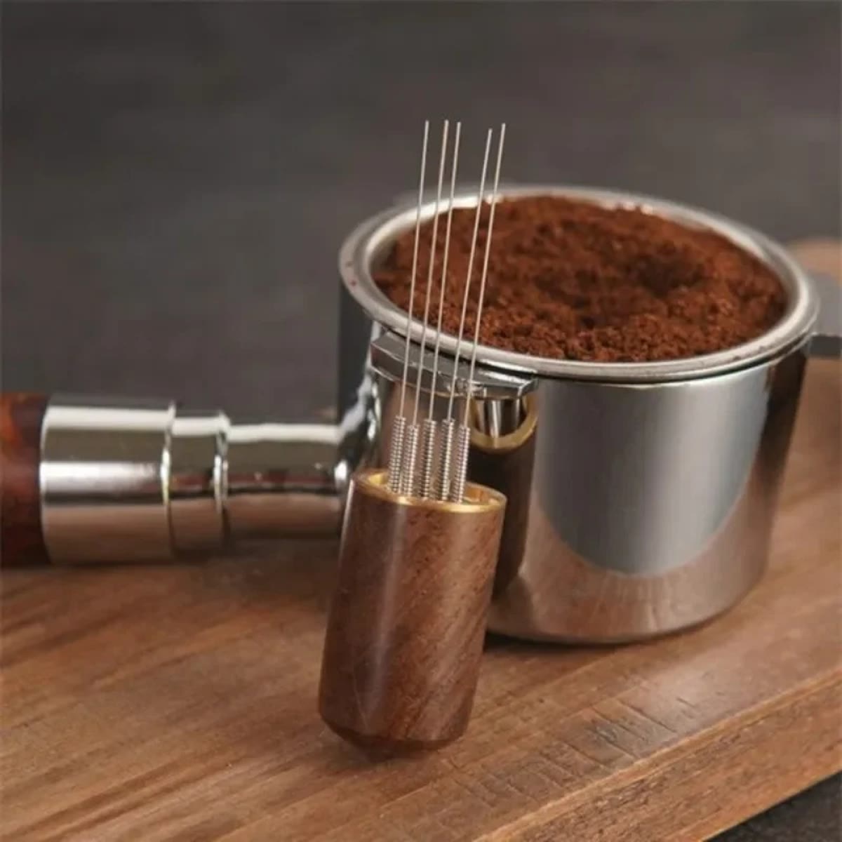 WDT-tool met dunne naalden en houten handvat voor een filtermand met koffiepoeder